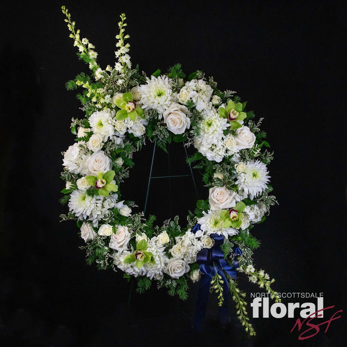 Elegant custom standing wreathe featuring white flowers and greenery, perfect for condolences. Florist in Scottsdale.